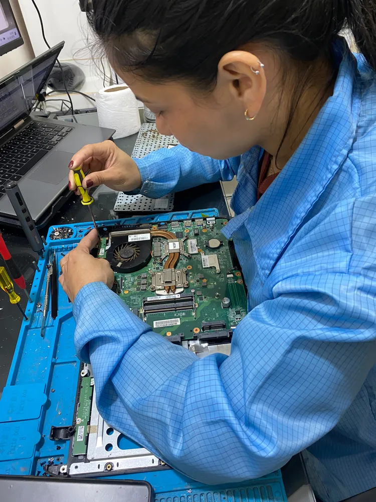 Profissional da equipe trabalhando na placa de um notebook