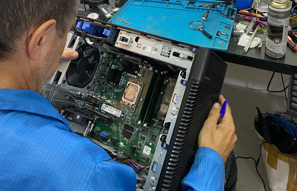 Profissional da equipe trabalhando nos componentes de um computador